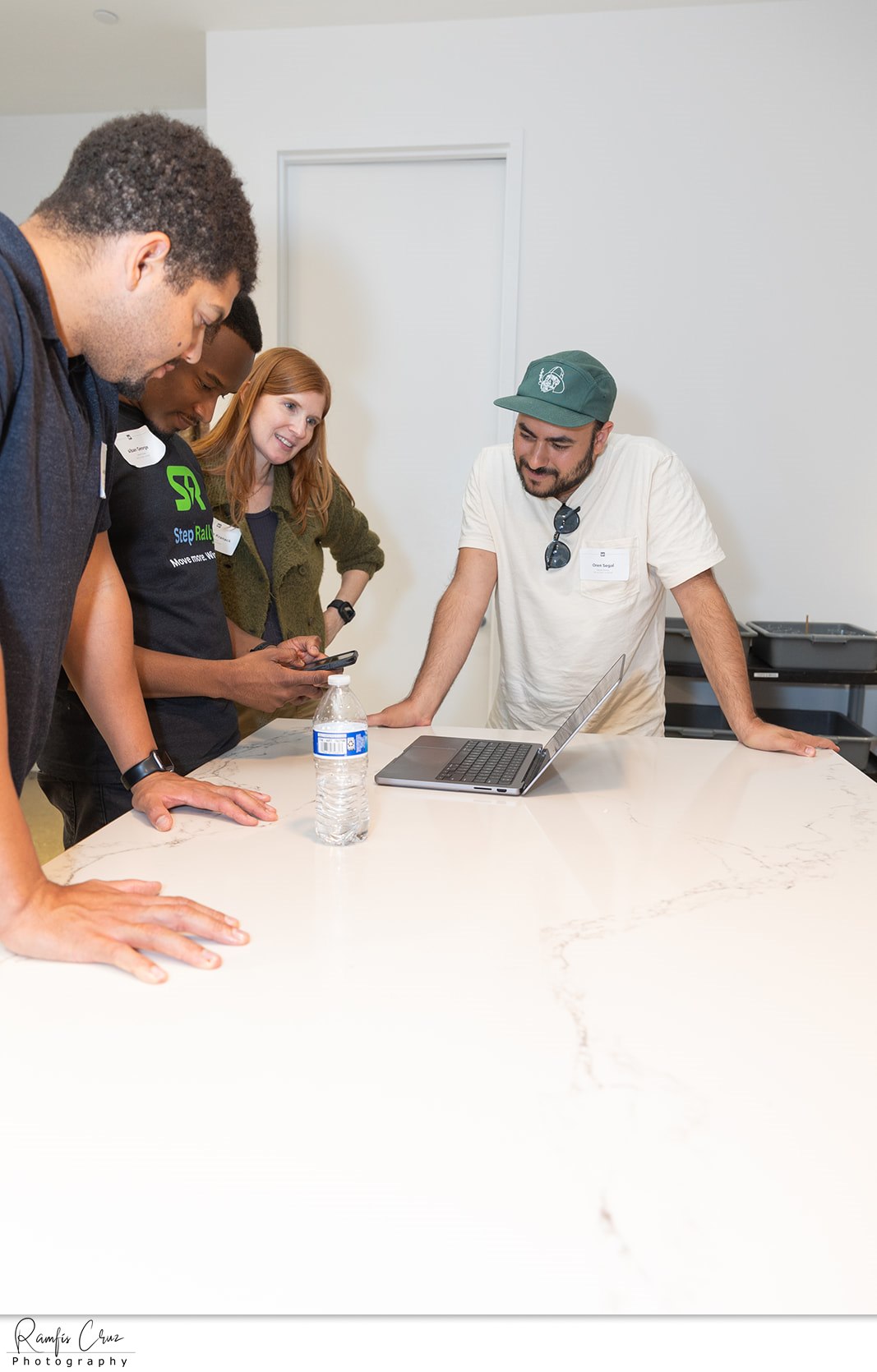 A small group gathered around a laptop demoing their product