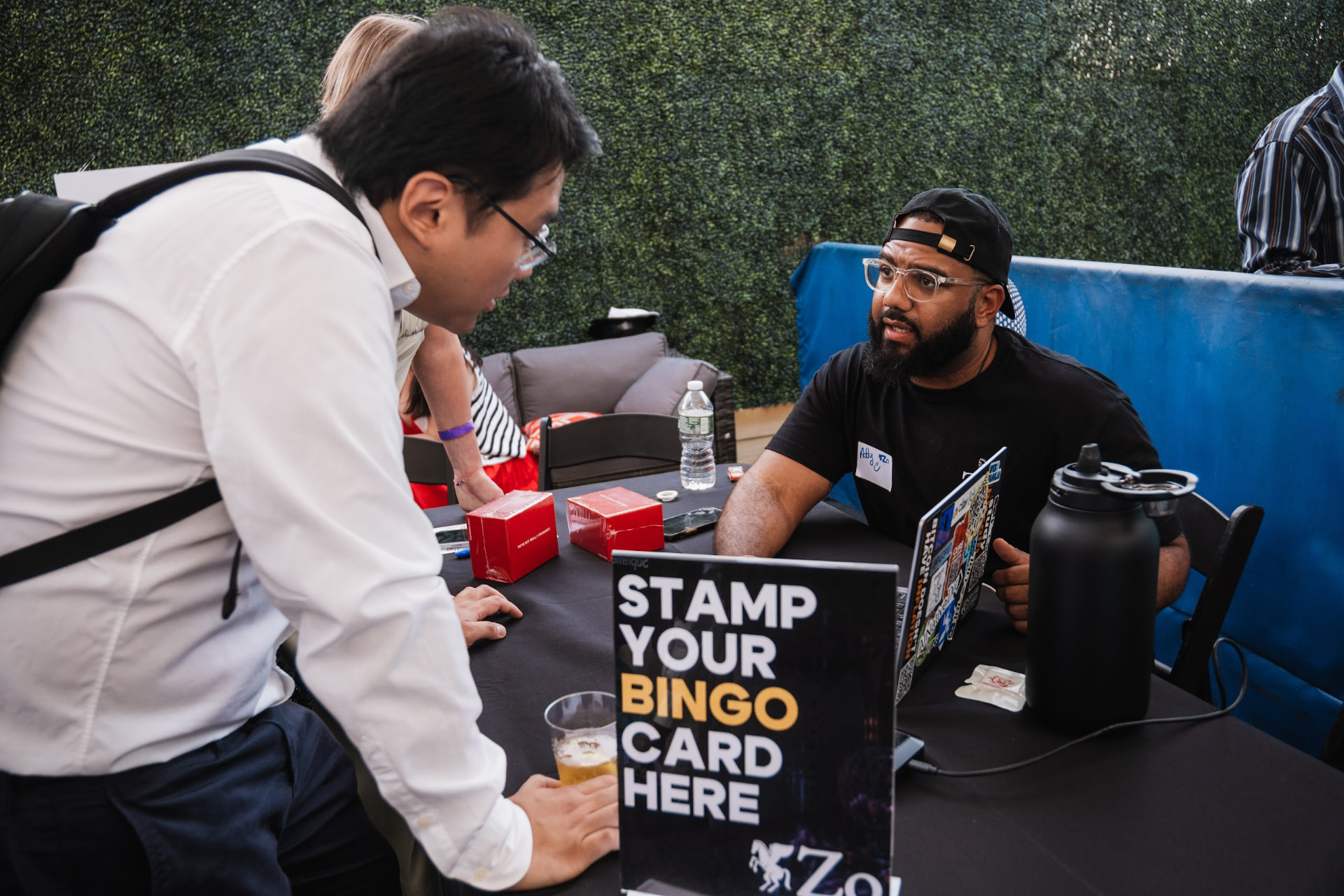 A builder chatting with a sponsor at a check-in table